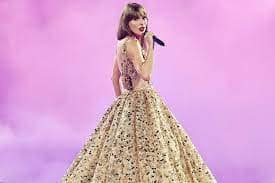 Taylor Swift at the 'Eras' tour singing 'Enchanted'. She's in a cream ballgown with sparkles.