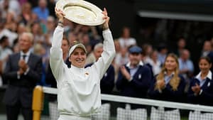 Marketa Vondrousova on the court smiling and holding her trophy over her head.