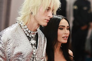 Machine Gun Kelly wearing necklace next to Megan Fox