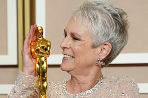 Jamie Lee Curtis smiling at her Oscar at the after show red carpet.