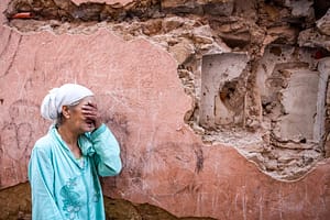 A woman reacts (crying) to Morocco earthquake in front of damaged home