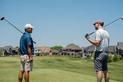 two men golfing on a sunny day with blue skies