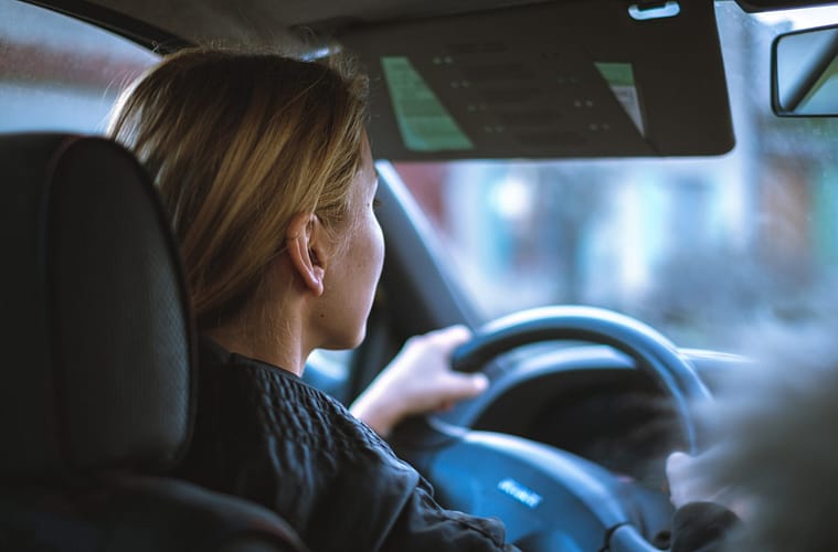 a young teenage girl driving a car
