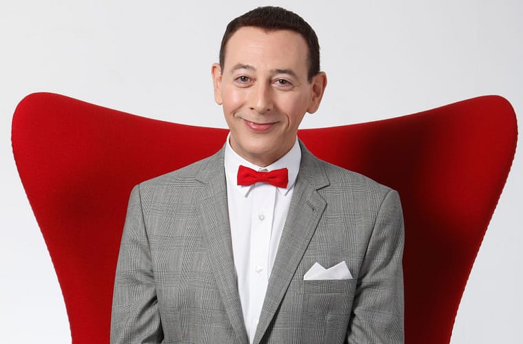 Paul Reubens as Pee-wee Herman sitting in a big red chair